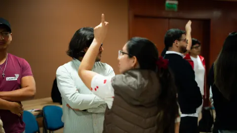 Participante levantando la mano para intervenir en una dinámica del taller Ágil de Verdad Edición 01 en Lima