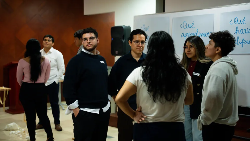 Retrospectiva real — ¿qué aprendimos? ¿qué haría diferente? Ed. 01 Grupo de participantes frente a la pizarra con las preguntas qué aprendimos y qué haría diferente en Ágil de Verdad Edición 01