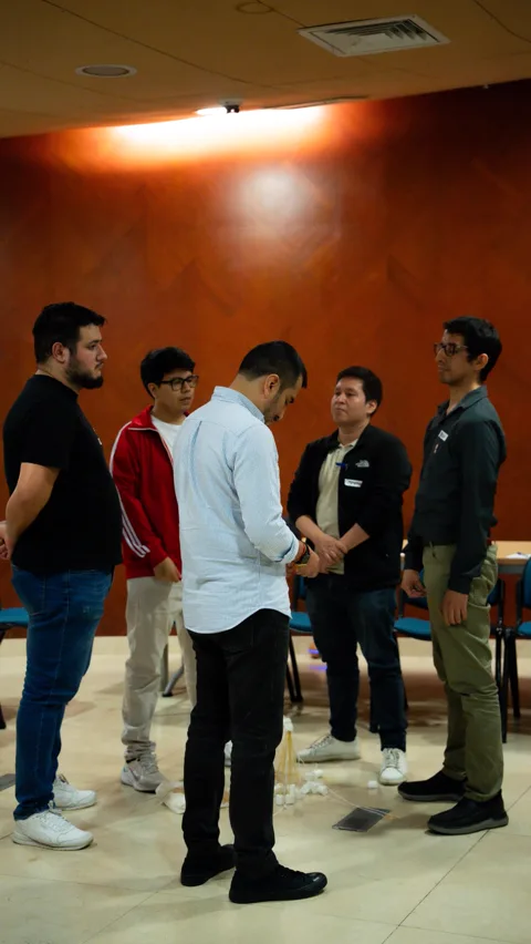 Grupo de profesionales de pie en círculo conversando durante el taller Ágil de Verdad Edición 01 en Lima