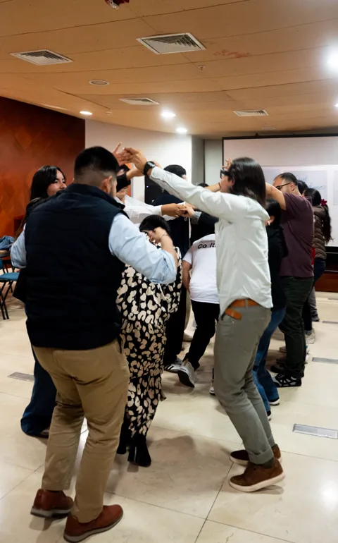 Participantes tomados de las manos en una dinámica grupal de coordinación en el taller Ágil de Verdad Edición 01