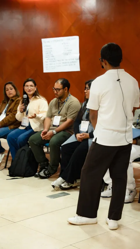 Participante hablando con micrófono en dinámica de conversación del Full Day RECO Espejo Edición 01